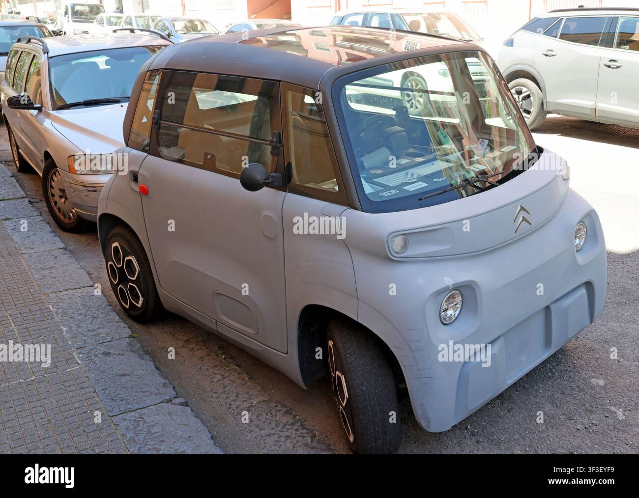 Tiny Citroen Ami electric quadricycle parked in Messina, Sicily, offering low-speed, short-range transport for congested European city streets. Stock Photo