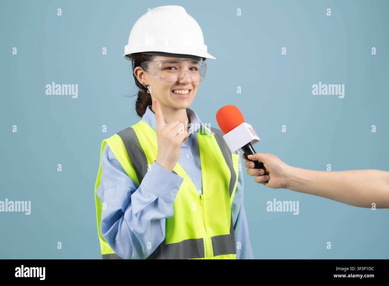 Female worker answering reporter microphone interview questions studio Stock Photo