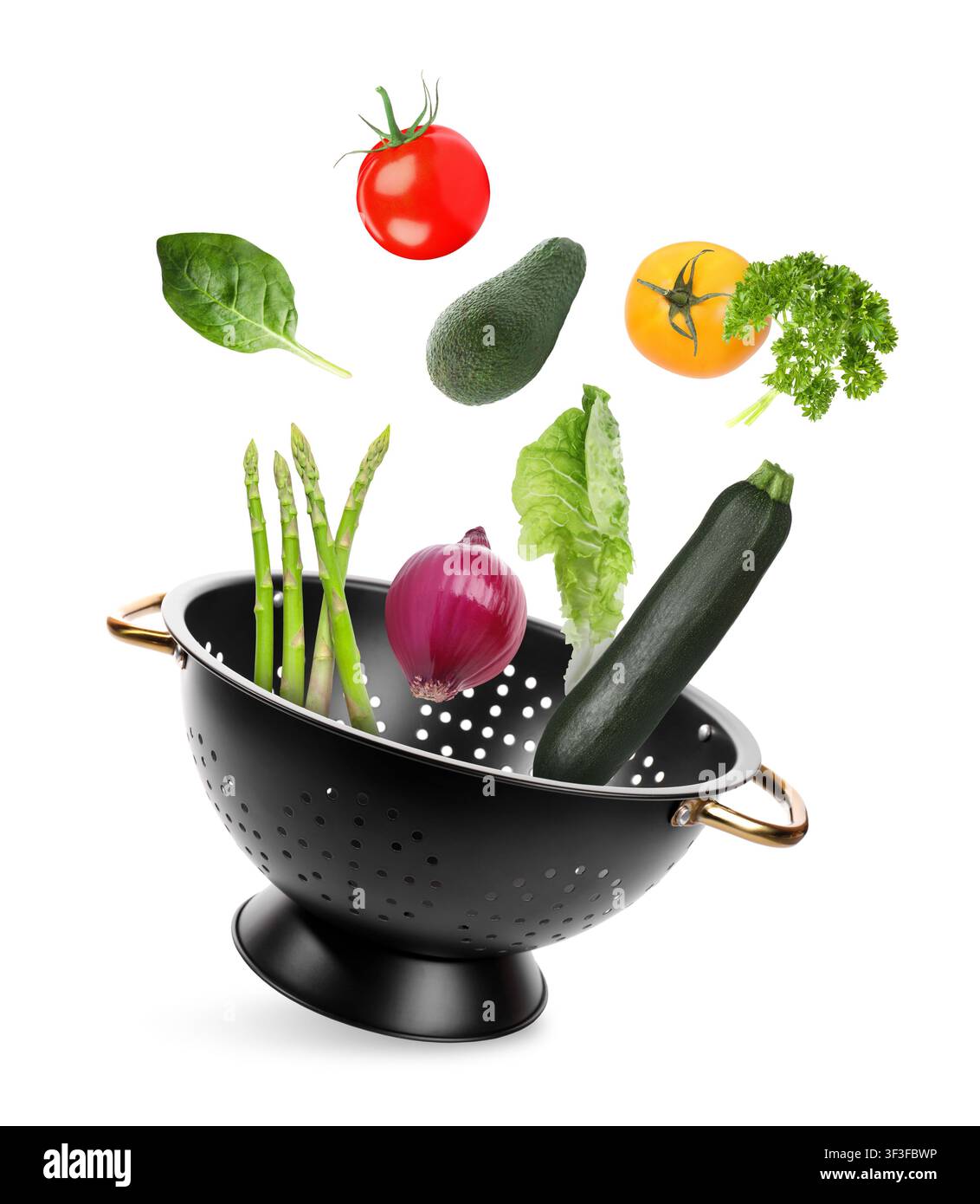 Vegetables and colander flying in air on white background Stock Photo