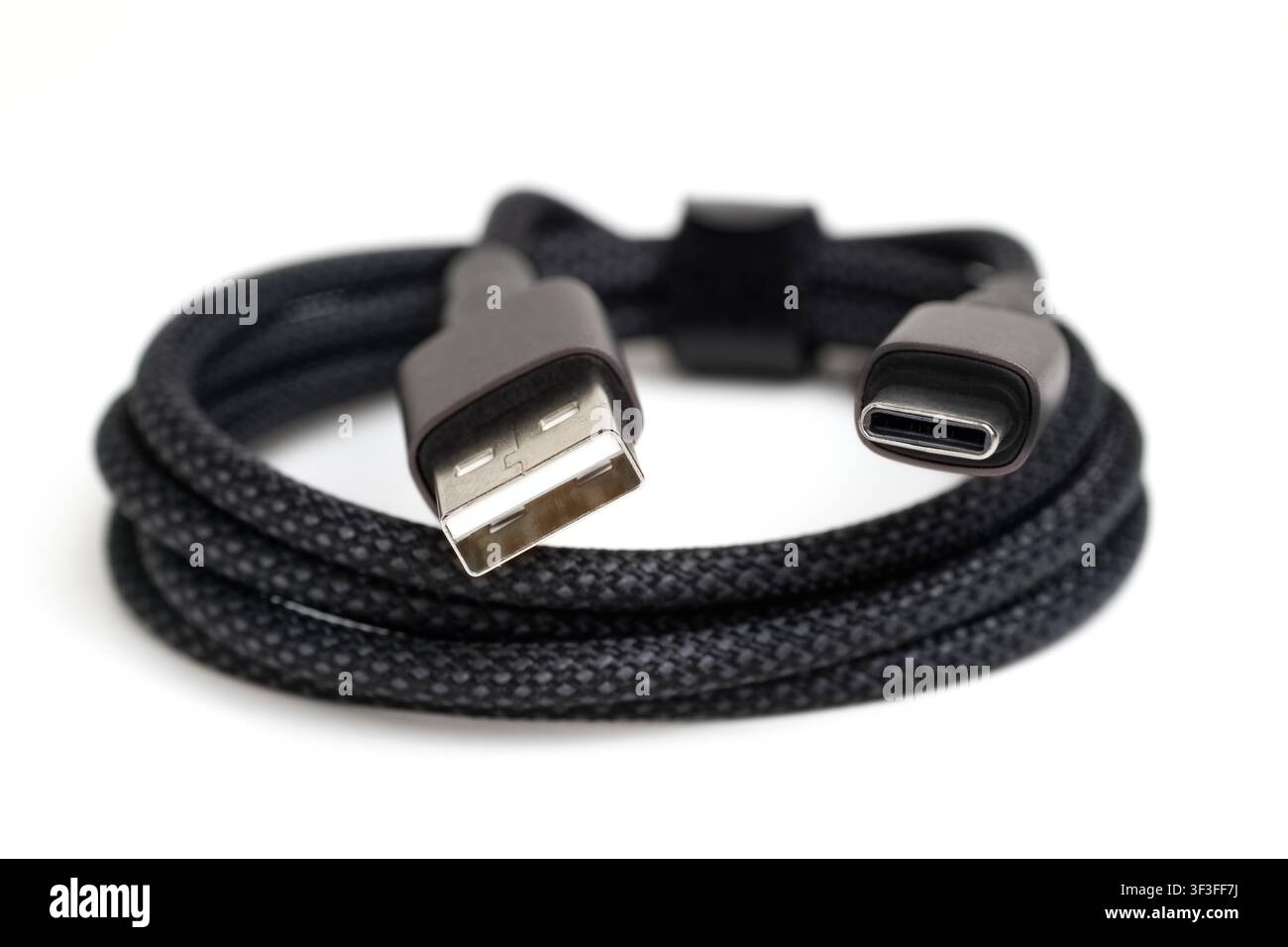 usb-a to usb-c cable coiled, showing both connectors on white background Stock Photo
