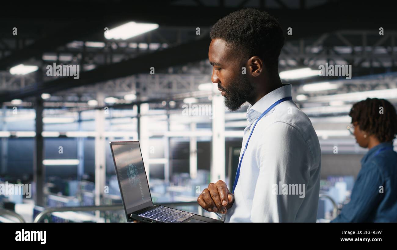 Server hub teamworking IT experts visualizing large language model architecture using notebook. Data center system administrators on industrial platform collaborating on tasks using laptop Stock Photo
