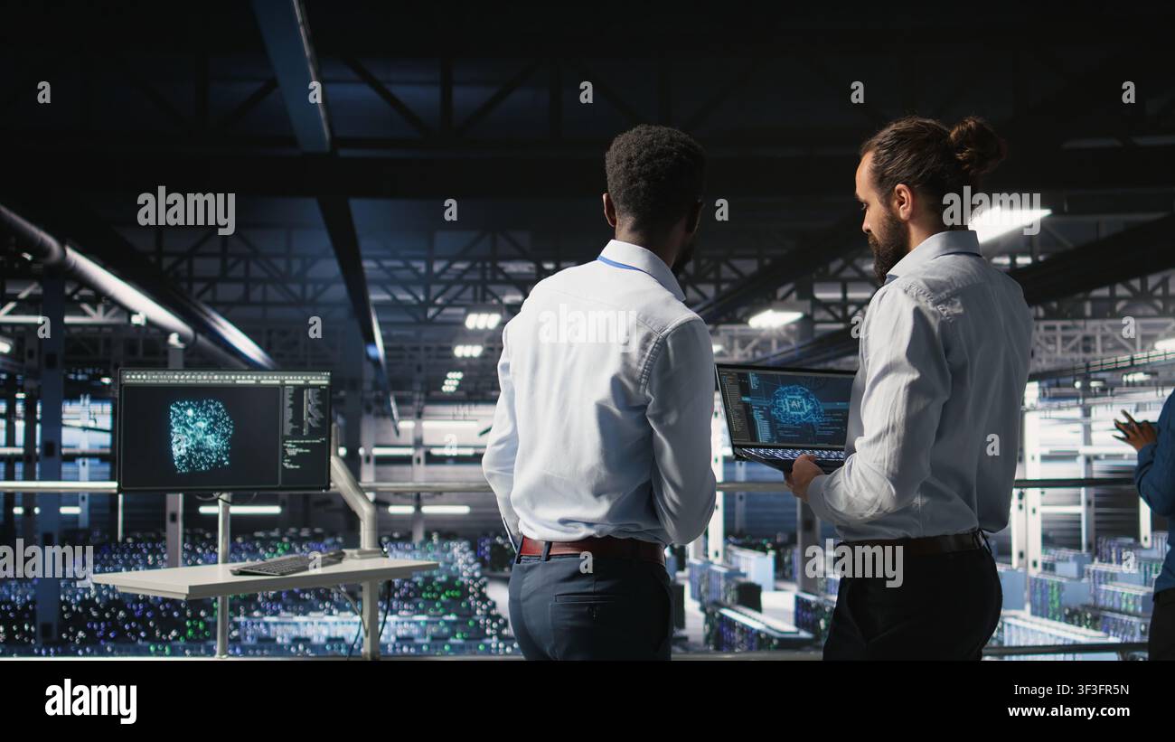 Data center workers cooperating, doing maintenance on rigs handling AI processing tasks. Server hub admins doing brainstorming, managing storage arrays supporting deep learning technology, Stock Photo