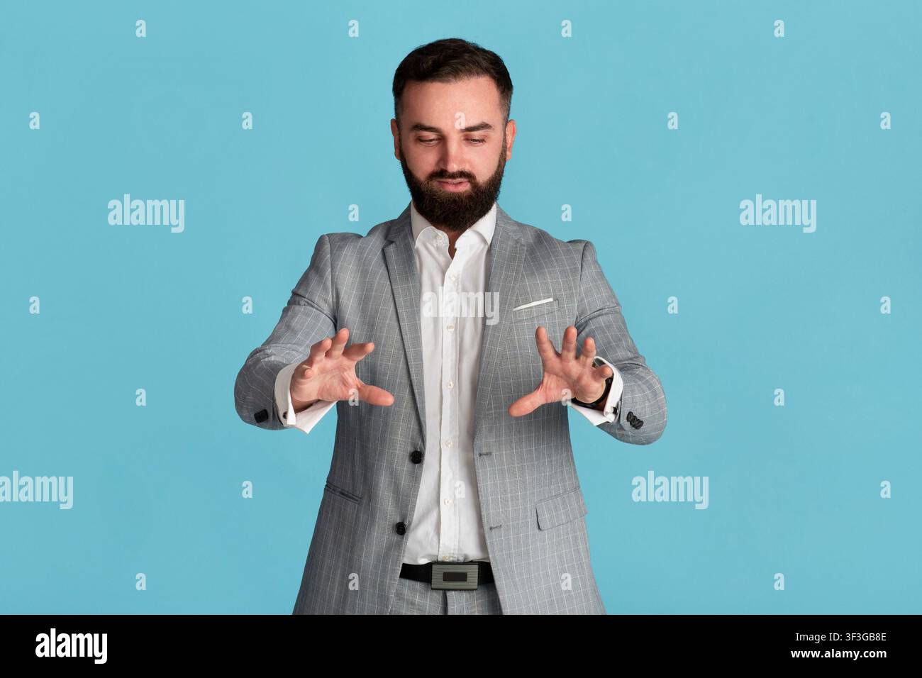 Serious young entrepreneur touching interactive virtual screen on blue background, space for design Stock Photo