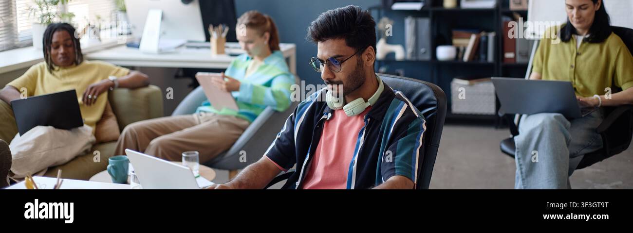 Diverse Coworkers Working on Laptops in Modern Shared Office Stock Photo