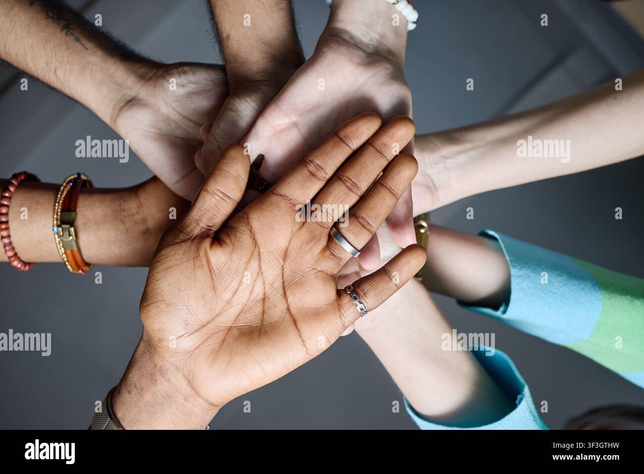Diverse Team Joining Hands for Workplace Unity and Collaboration Stock Photo