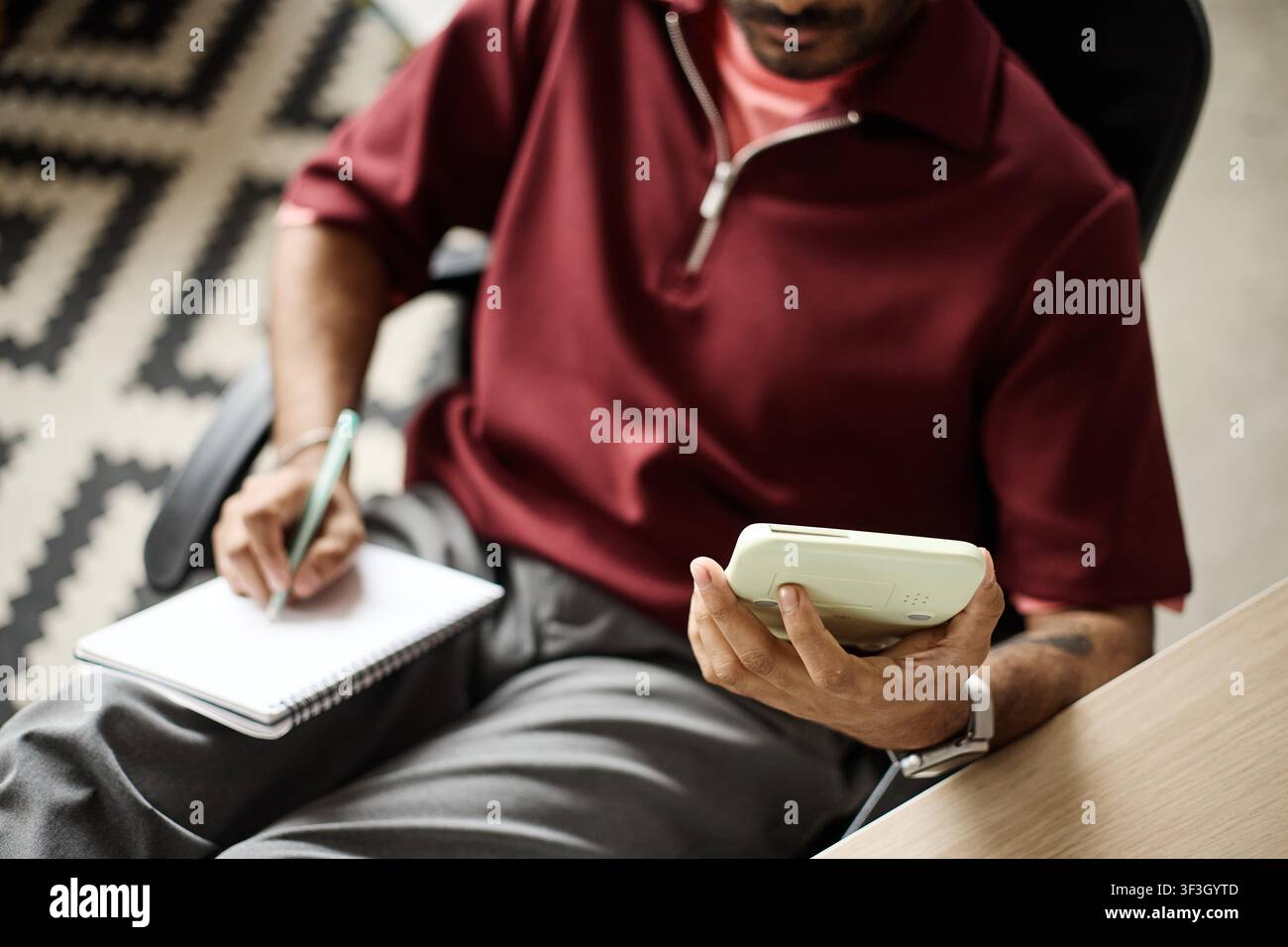 Adult Man Using Calculator and Writing Notes While Working Stock Photo