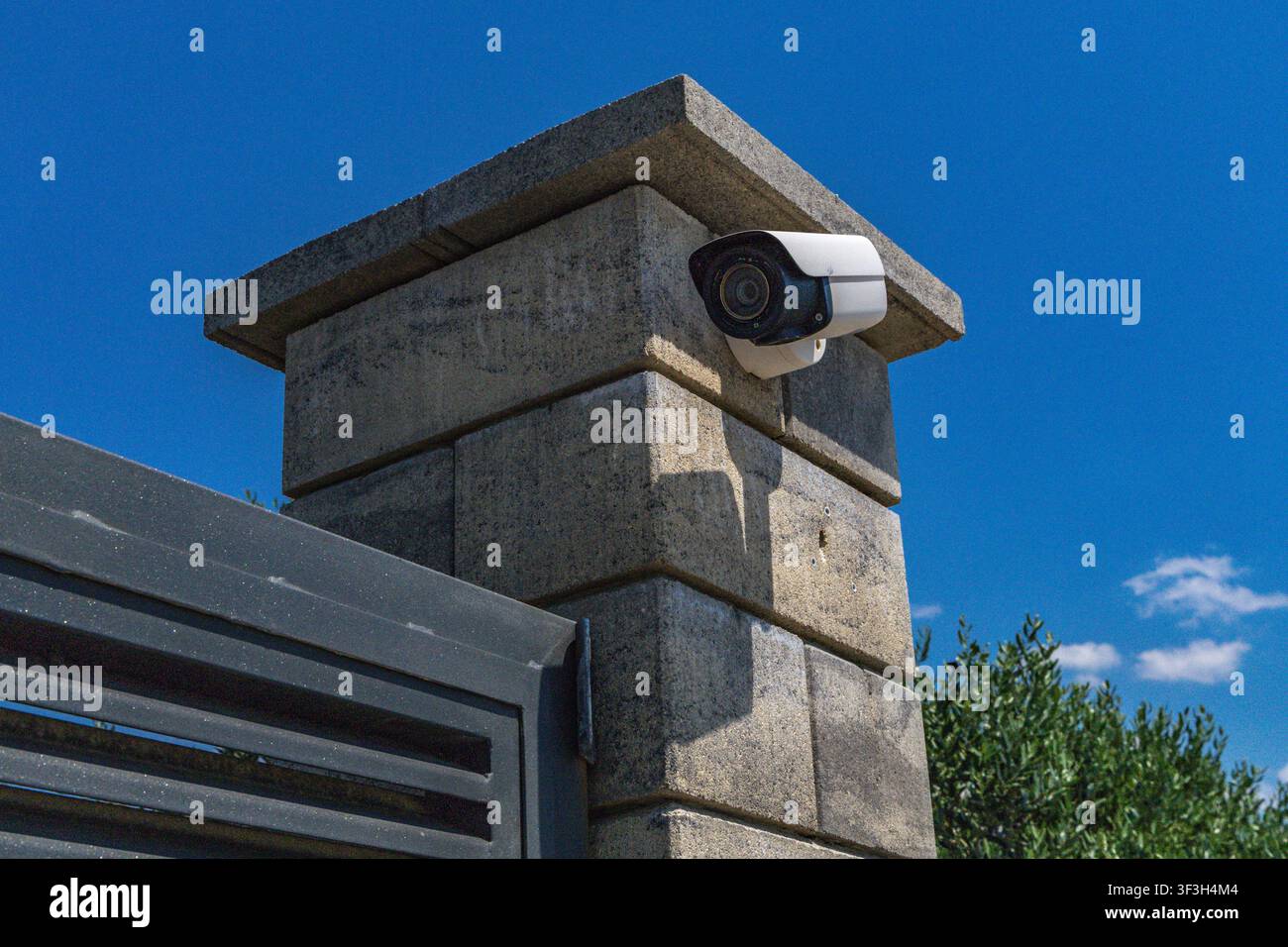 Video surveillance camera installed above the entrance gate to a luxury villa by the sea, security camera, fine for recording video and audio in a pub Stock Photo