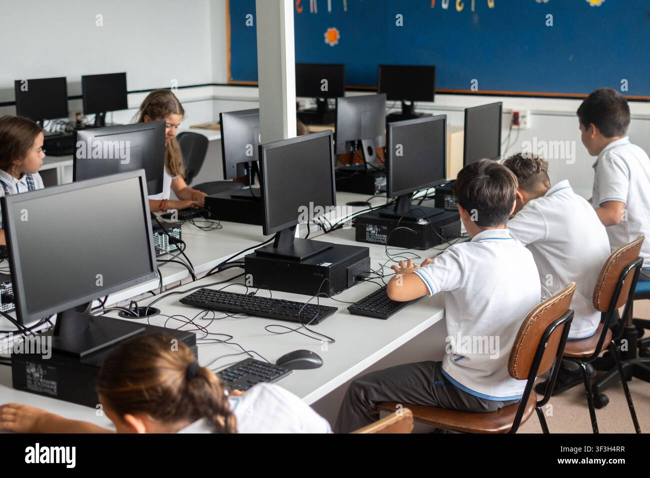 Elementary school students using desktop computers in computer lab Stock Photo