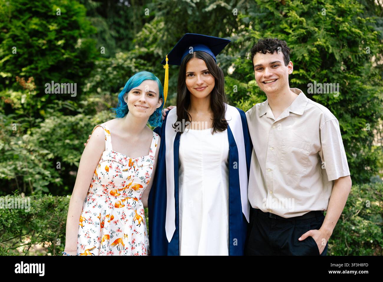 Siblings celebrating sister on her graduation day Stock Photo