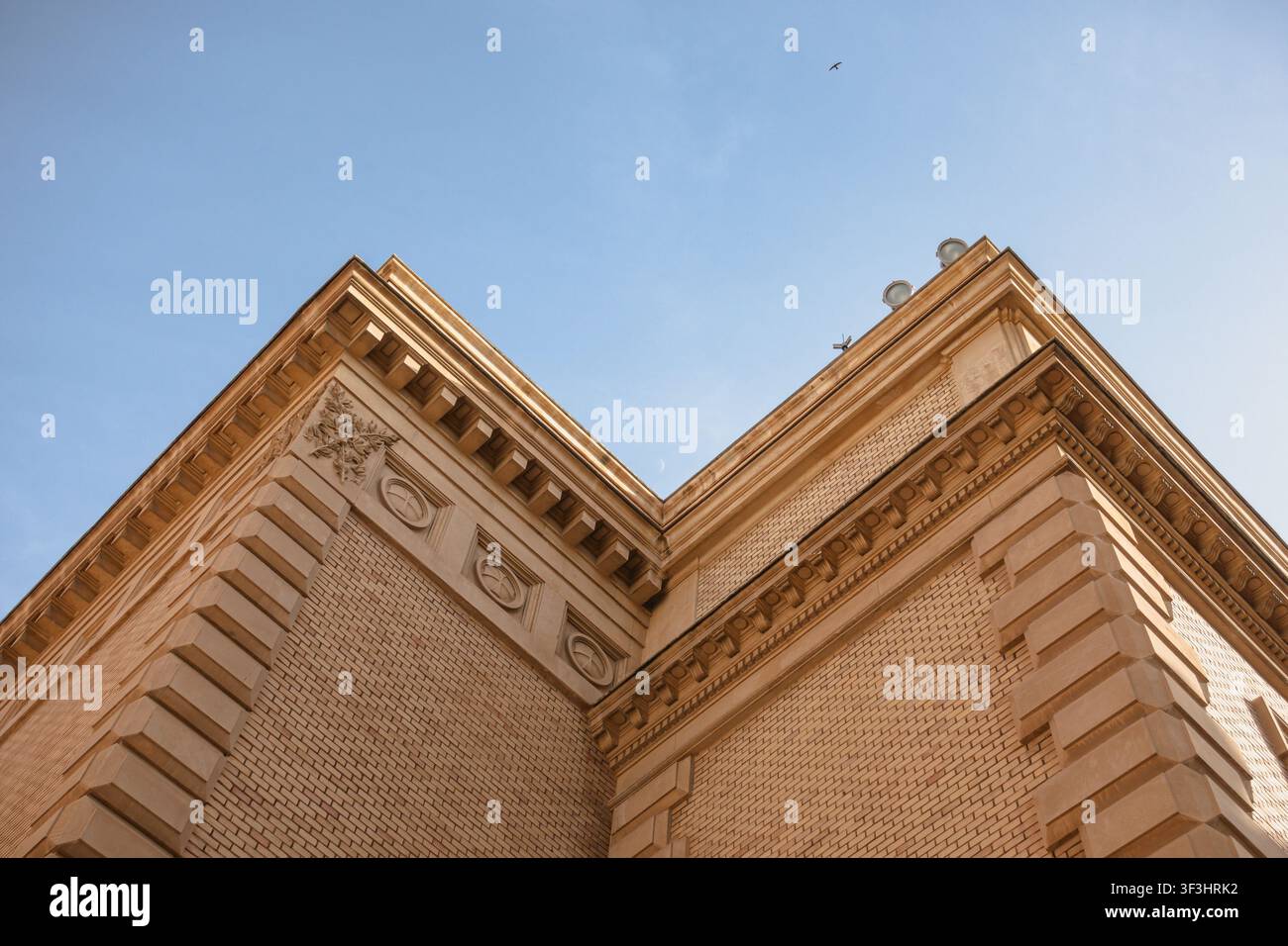 Historic Building Corner with Crescent Moon in Blue Sky Stock Photo