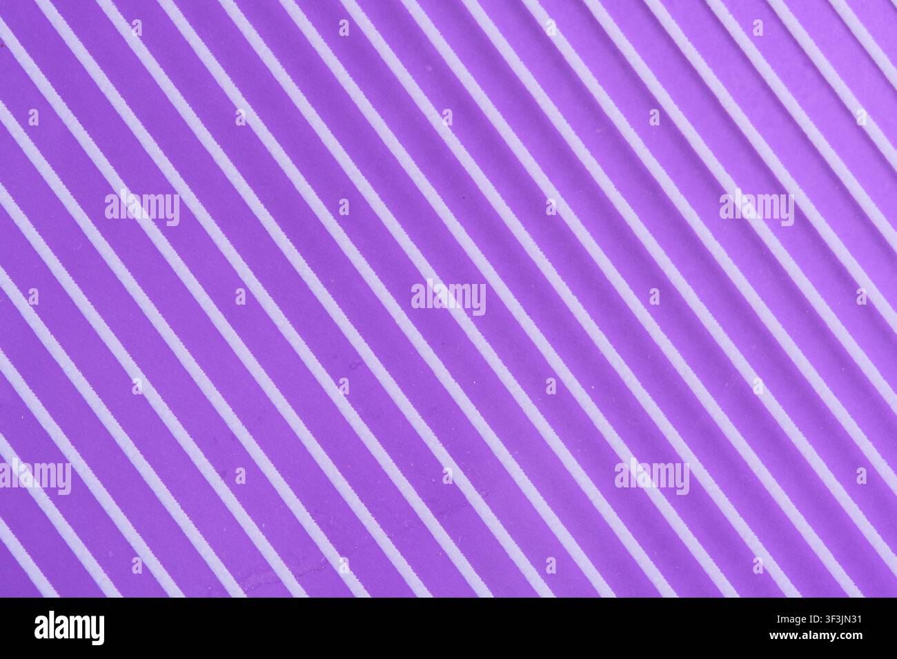 Abstract bright purple diagonal ribbed background texture with parallel white striped pattern Stock Photo