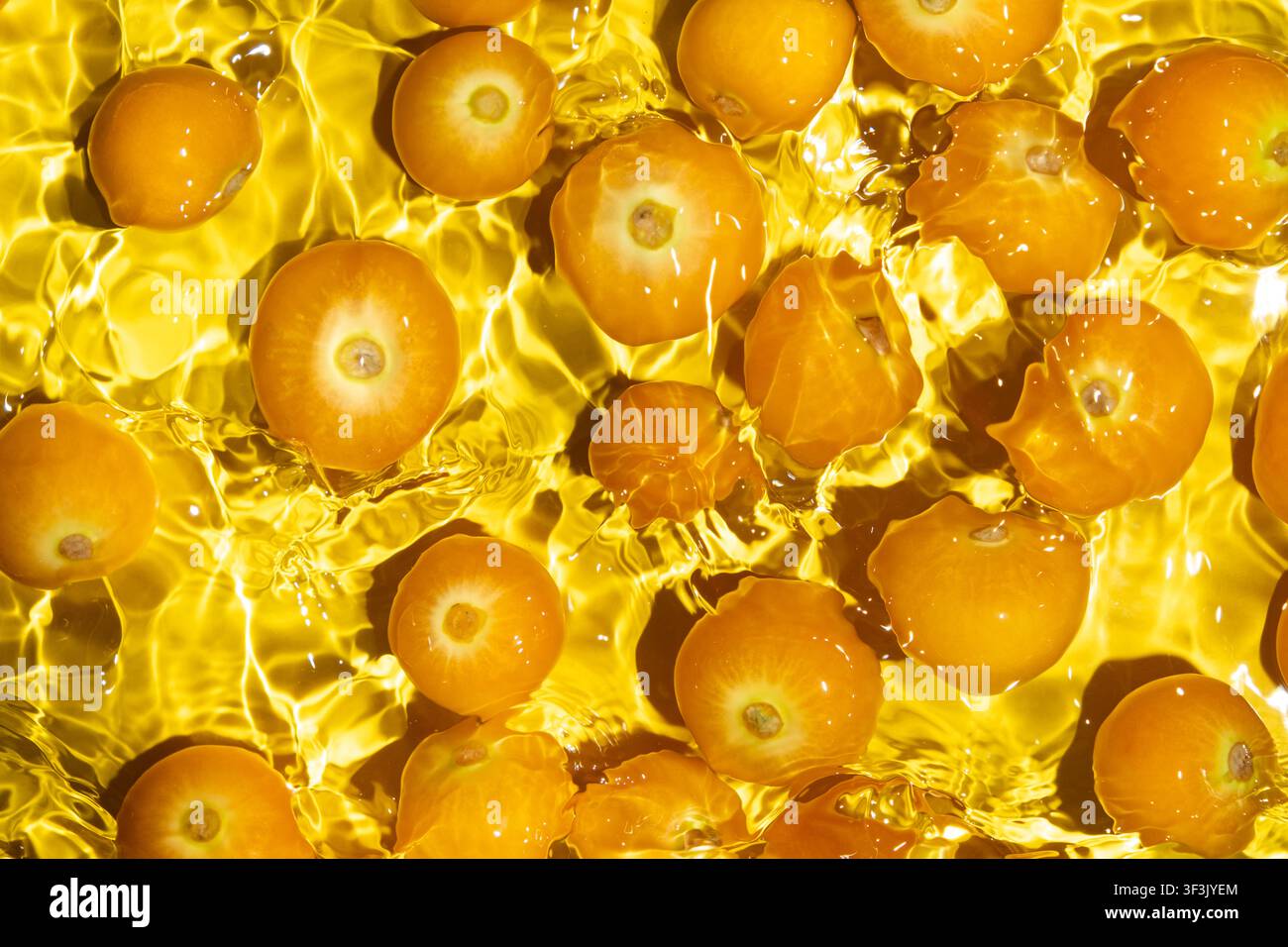 Fresh physalis berries in water splash for refreshing food concept. Stock Photo