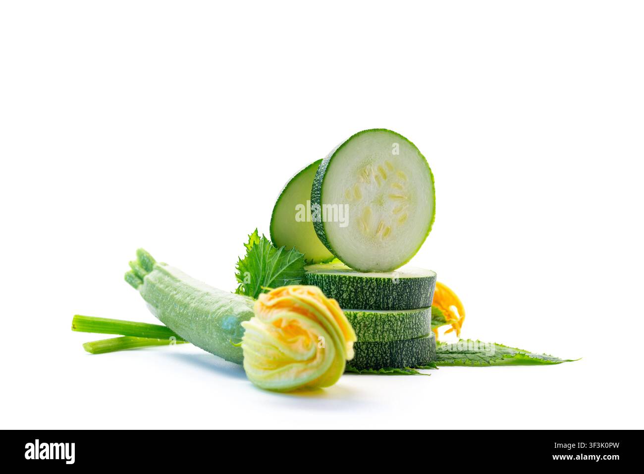 Organic zucchini slices with green leaves on clean white background . Stock Photo