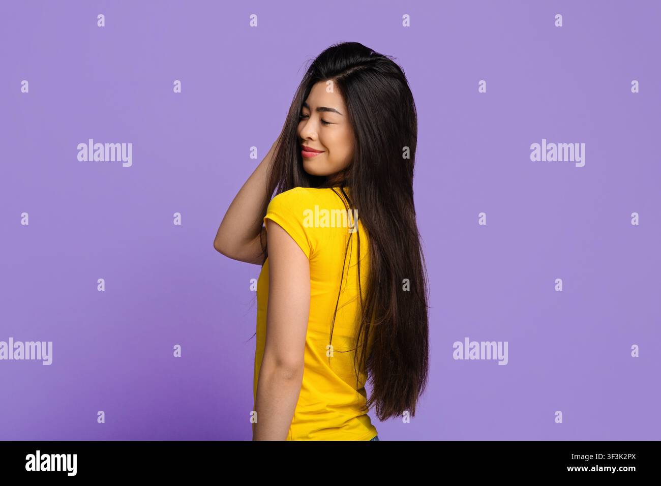 Young Asian Woman With Beautiful Natural Long Hair Posing Over Purple Background Stock Photo