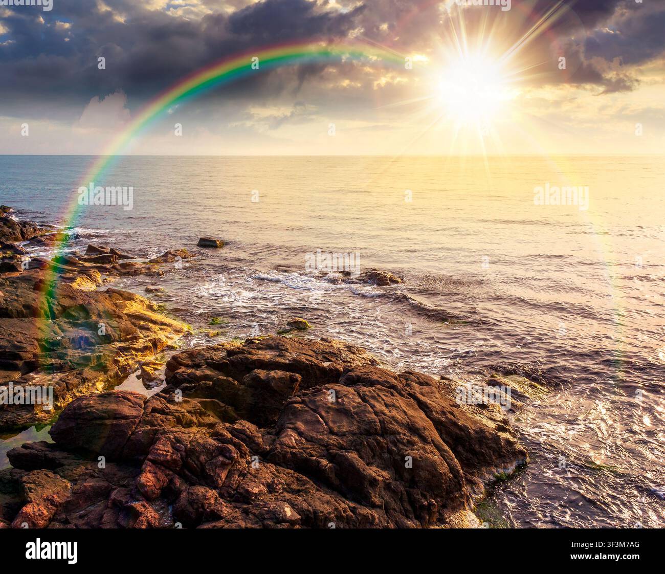 sunset over sea coast with stones and rocks. summer vacation background. seascape with rough terrain. relaxing at the sea. coast of bulgaria. weather Stock Photo