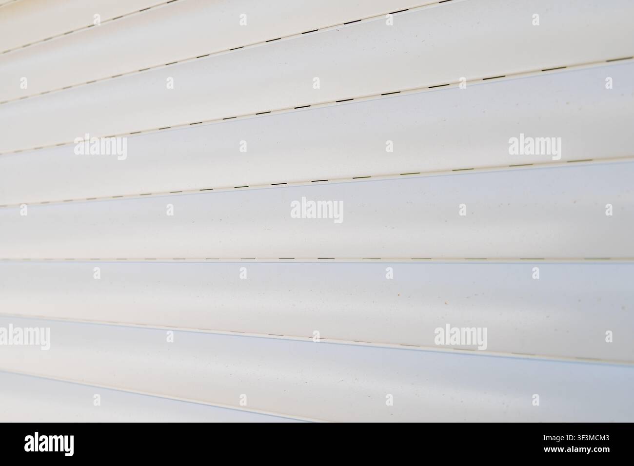 A detailed abstract background showcasing the clean lines and subtle texture of white horizontal window blinds, creating a sense of order and simplici Stock Photo