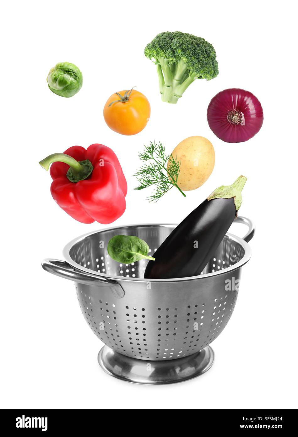 Different fresh vegetables falling into colander on white background Stock Photo