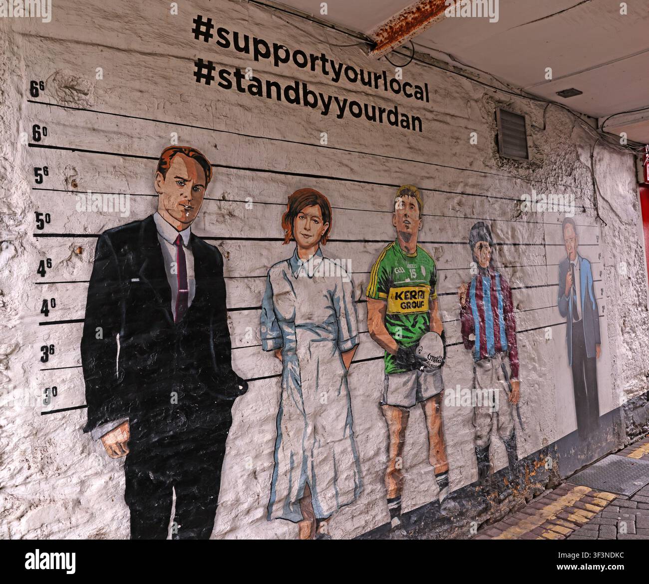 Support Your Local mural in Killarney, County Kerry, Ireland, showing healthcare and community figures. Stock Photo