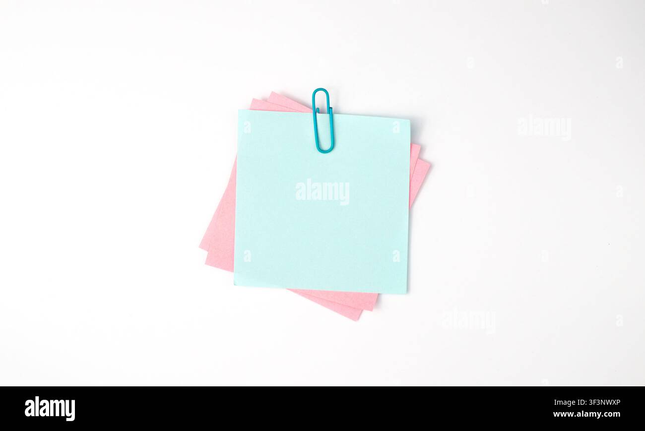 Pastel Sticky Notes with Blue Clip on White Background Stock Photo