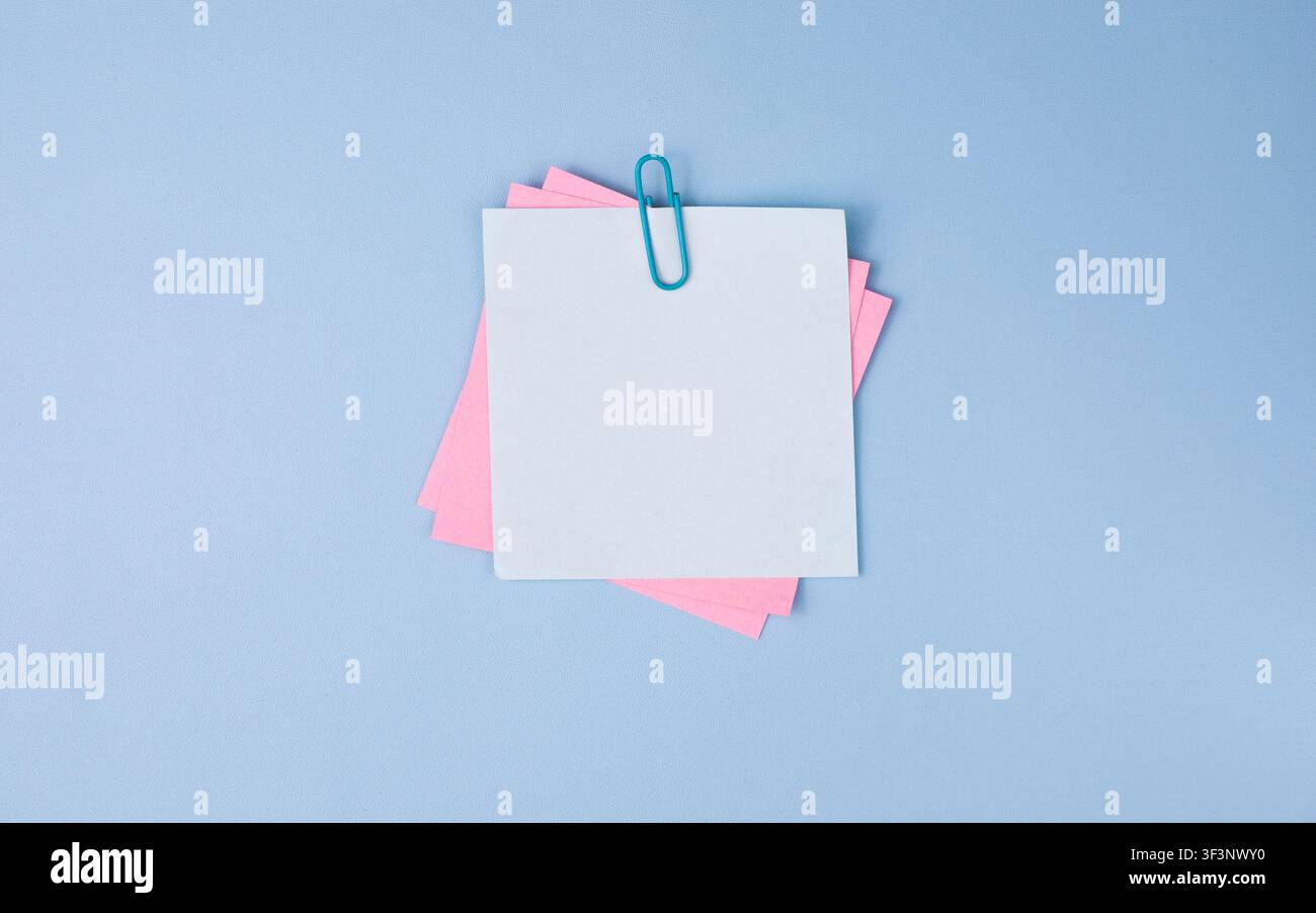 Pastel Sticky Notes with Paper Clip on Blue Background Stock Photo