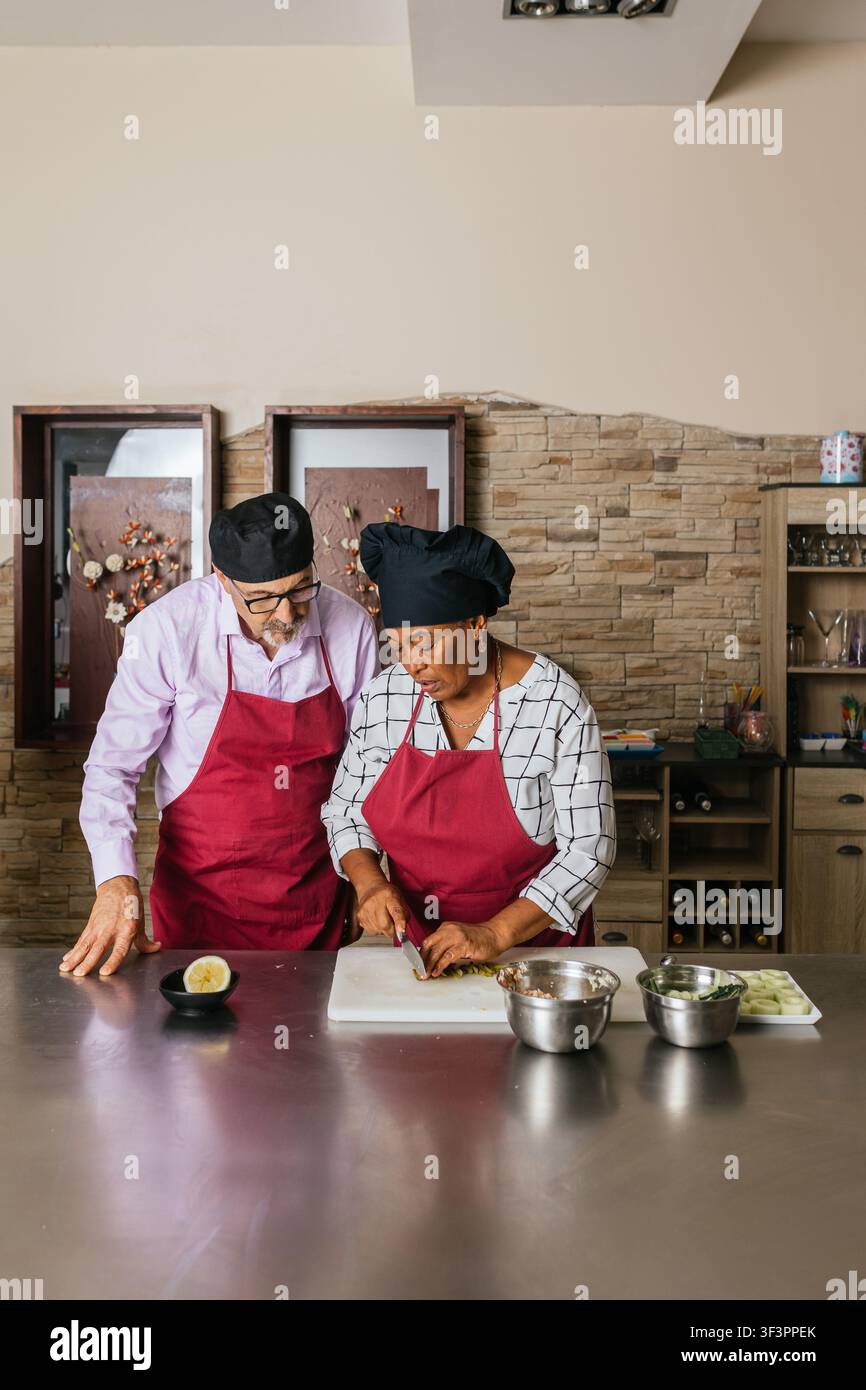 Chefs preparing ingredients during cooking course in restaurant kitchen Stock Photo