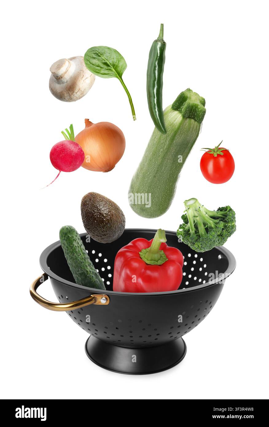 Different fresh vegetables falling into colander on white background Stock Photo