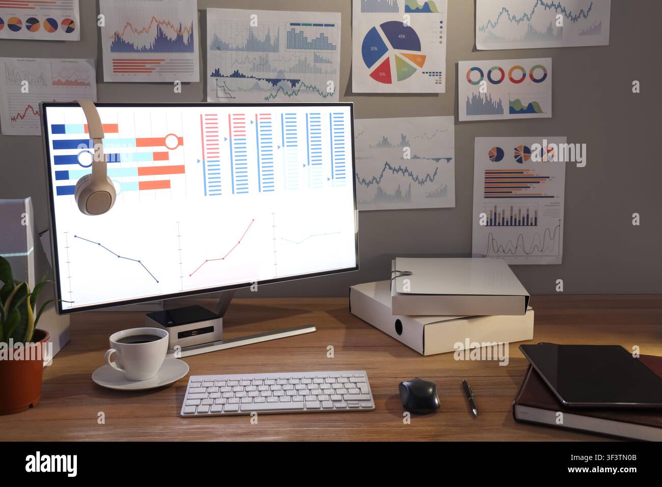 Data scientists workplace with computer and diagrams in dark office Stock Photo