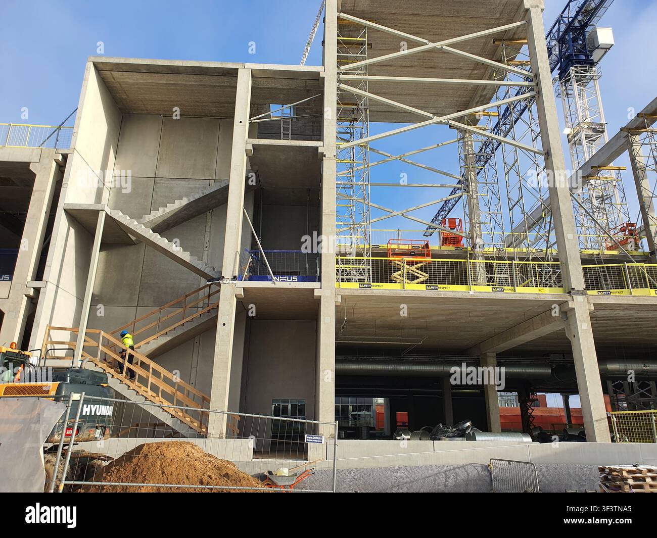 A large-scale commercial building construction site featuring exposed reinforced concrete columns, beams, and floor slabs forming a multi-level Stock Photo