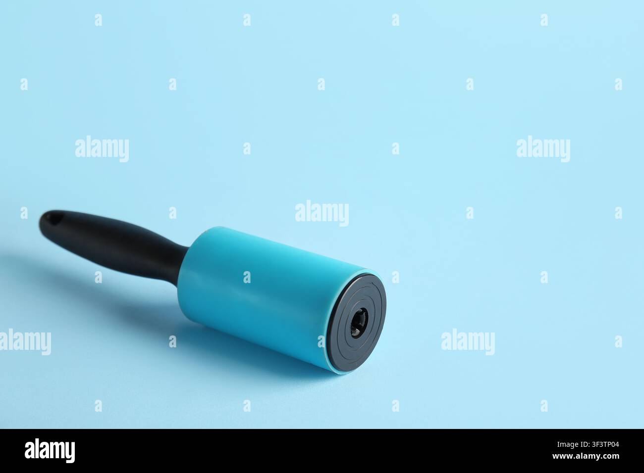 Lint roller on blue background Stock Photo