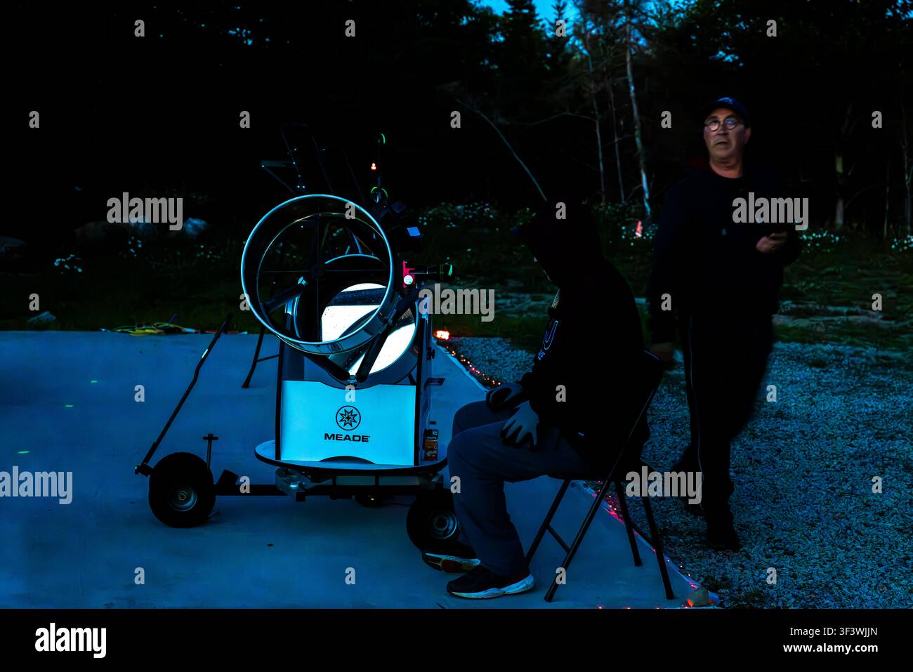 At dusk, the team of scientists sets up a mobile Meade telescope on the grounds of the Deep Sky Eye Observatory on Frotten Road in the Municipality of Argyle, Nova Scotia, Canada. The public telescope is mounted on a trolley and can be moved freely around the site Stock Photo
