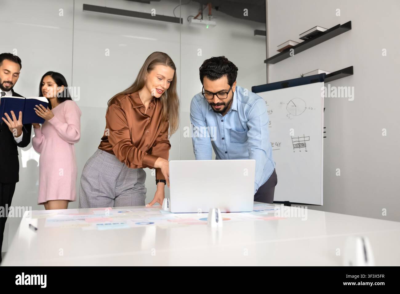 Business team analyzing financial data on laptop Stock Photo