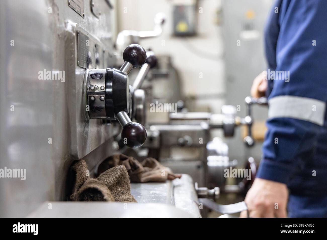 Industrial lathe machine operator working in metal machining workshop Stock Photo