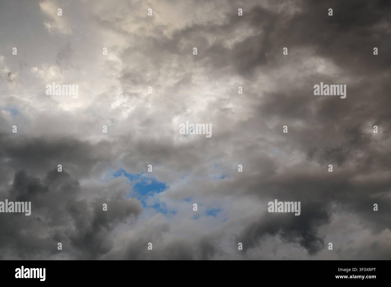 Dramatic storm clouds, sky, celestial landscape with clouds in the background and blue gaps Stock Photo