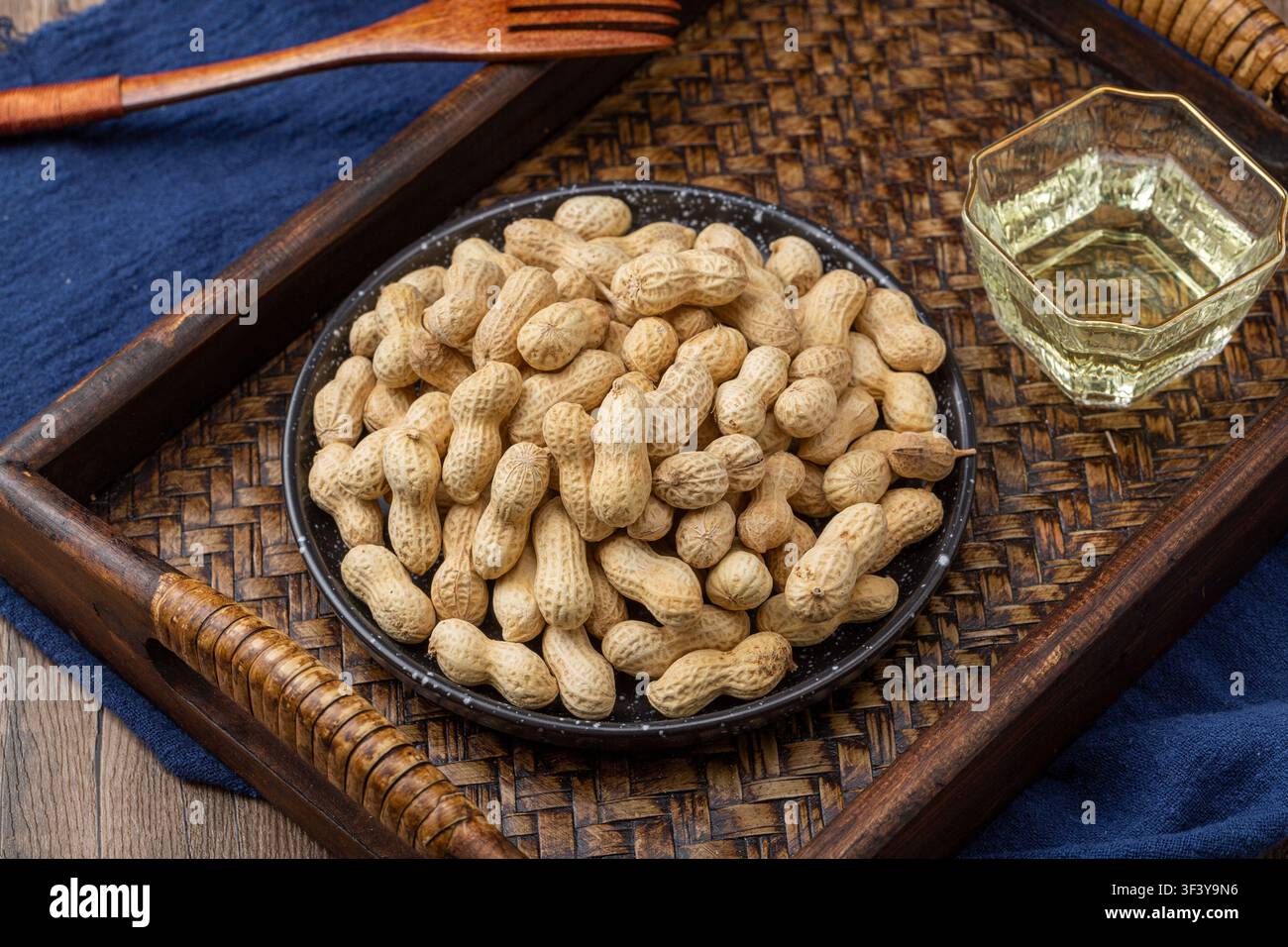 Roasted peanuts in shell served on blue dish Stock Photo