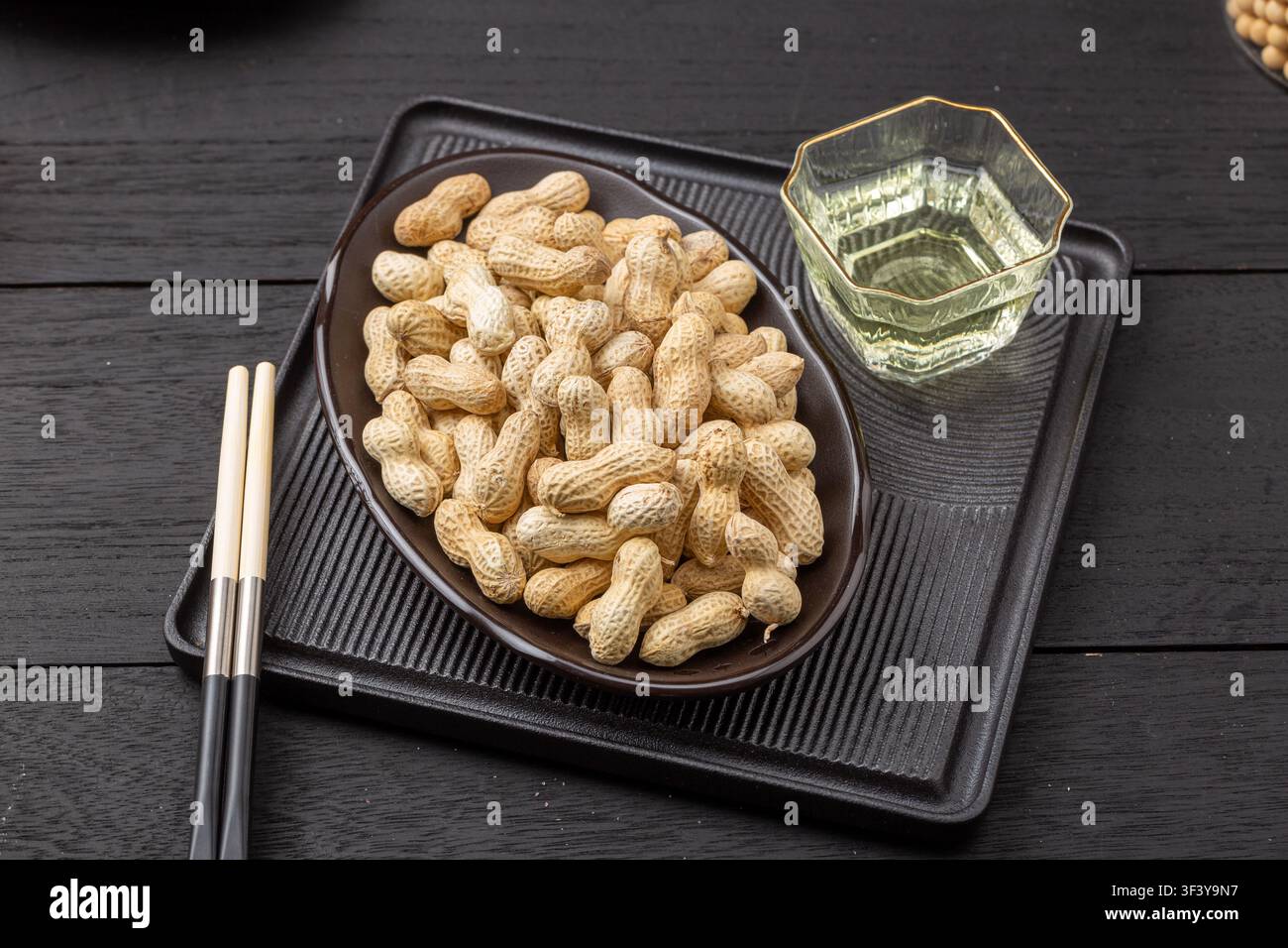 Roasted peanuts in shell served on blue dish Stock Photo