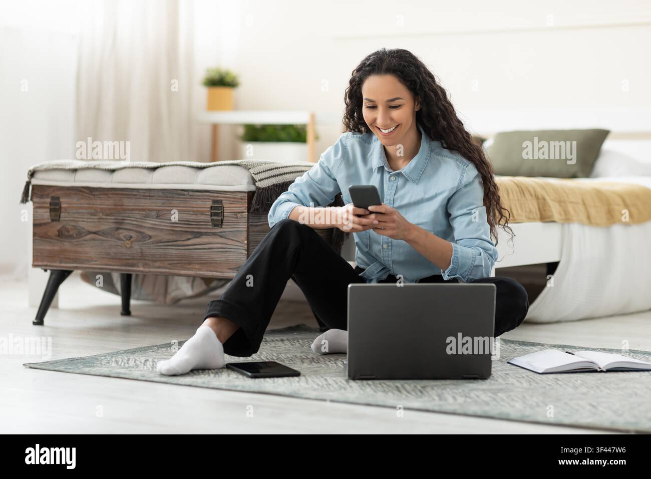 Happy Young Woman Using Smartphone And Laptop At Home, Study Concept Stock Photo