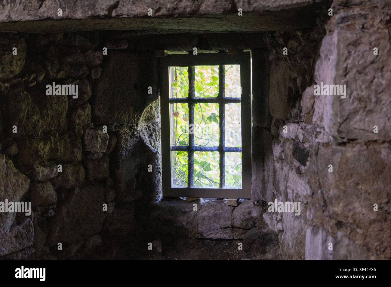 Deeply Recessed Window in Thick Ancient Stone Wall Stock Photo