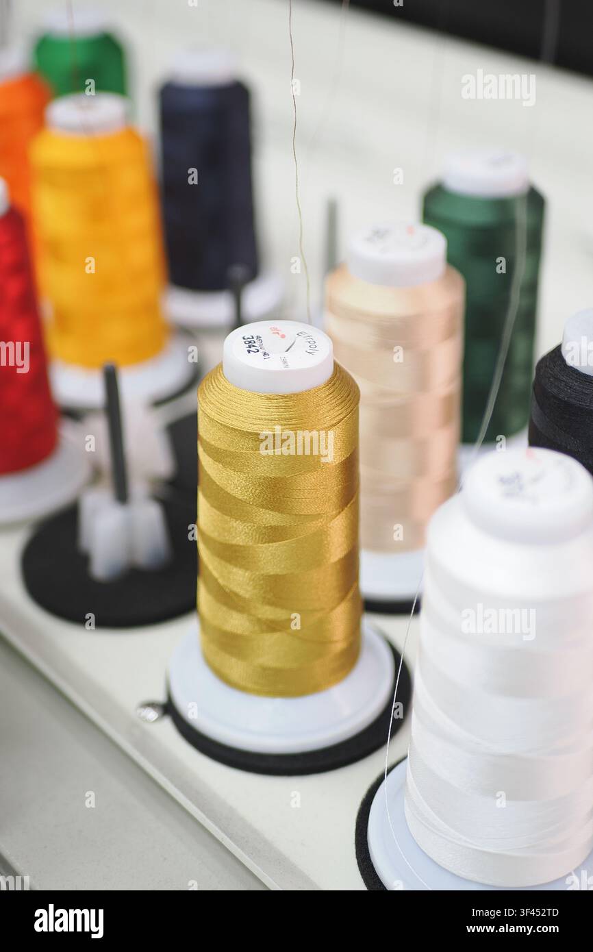Spools of thread in different colors on a work table Stock Photo