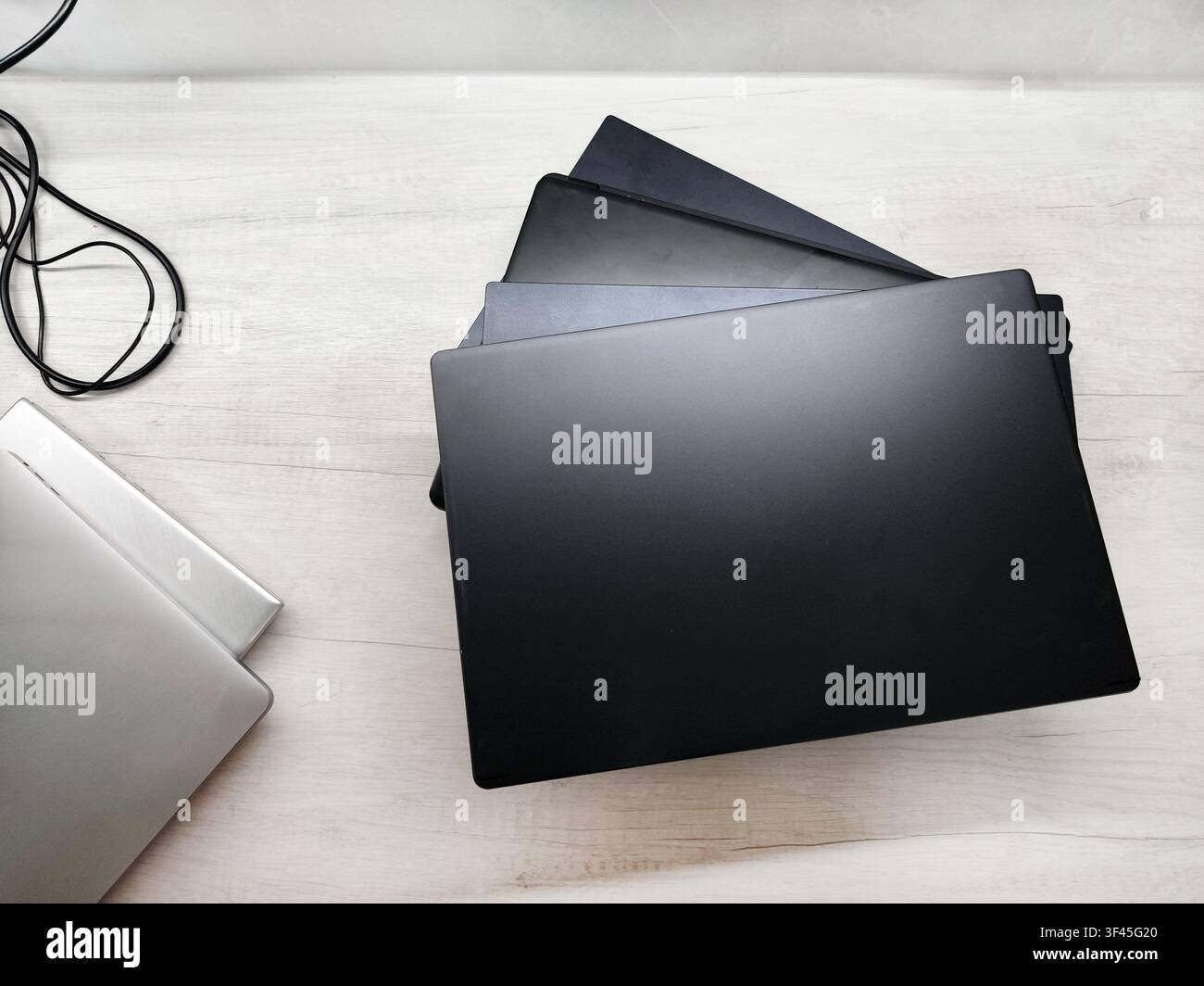 stack of laptops on a gray background, on the table, laptop computer, tablet, business, work, remote work, freelance. Stock Photo