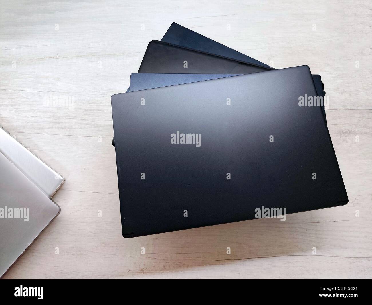 stack of laptops on a gray background, on the table, laptop computer, tablet, business, work, remote work, freelance. Stock Photo