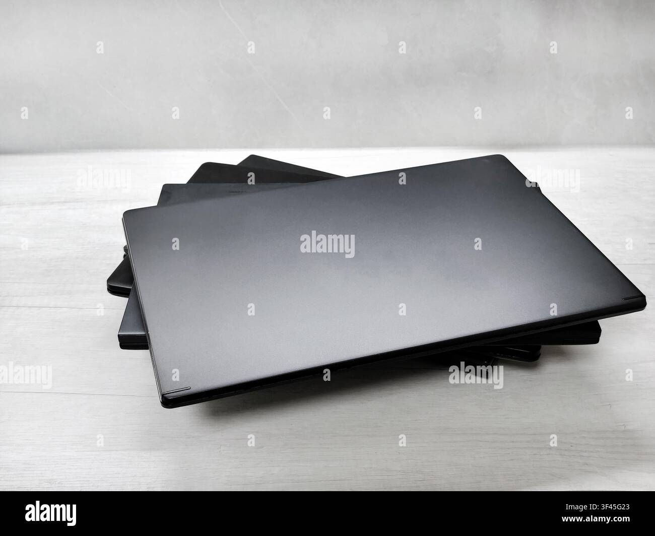 stack of laptops on a gray background, on the table, laptop computer, tablet, business, work, remote work, freelance. Stock Photo