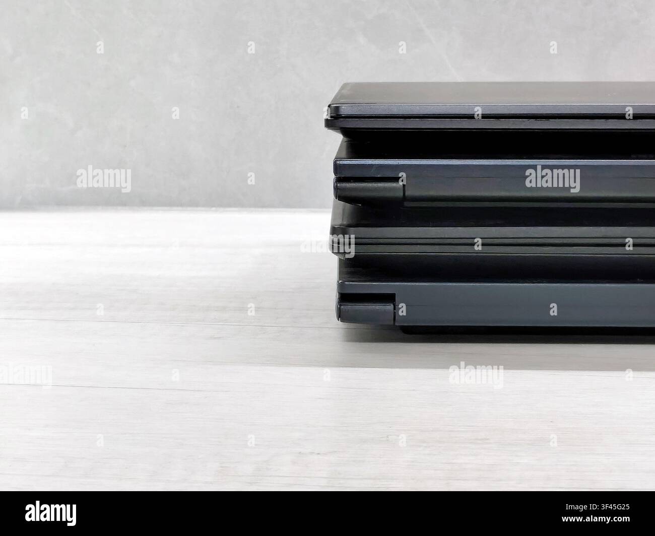 stack of laptops on a gray background, on the table, laptop computer, tablet, business, work, remote work, freelance. Stock Photo