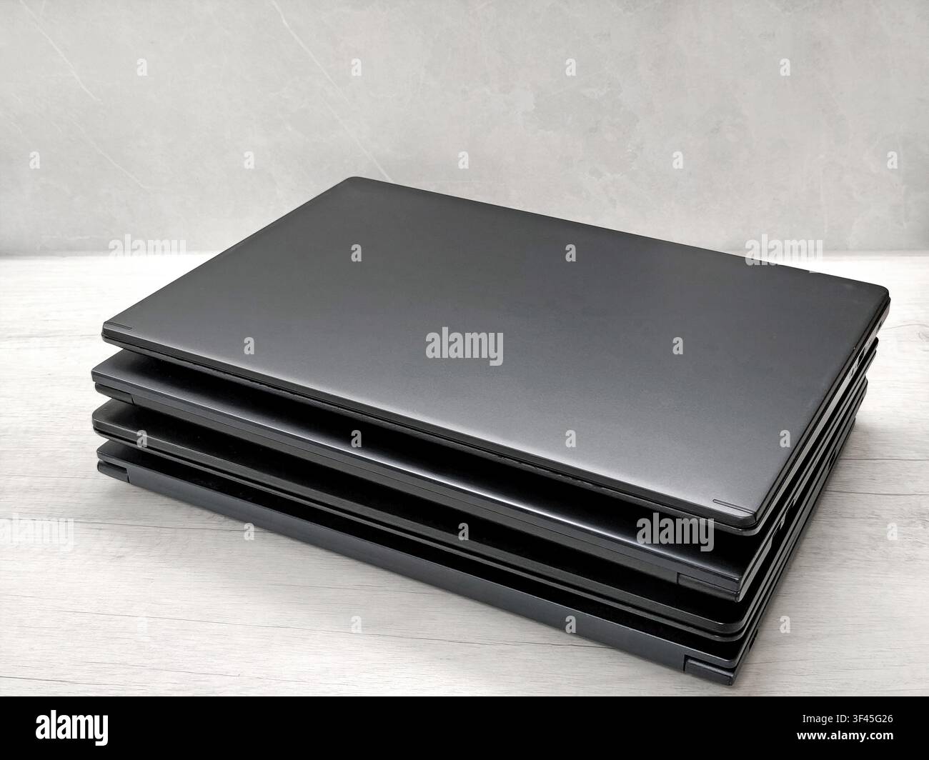 stack of laptops on a gray background, on the table, laptop computer, tablet, business, work, remote work, freelance. Stock Photo