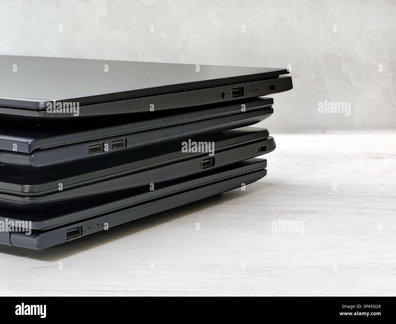 stack of laptops on a gray background, on the table, laptop computer, tablet, business, work, remote work, freelance. Stock Photo