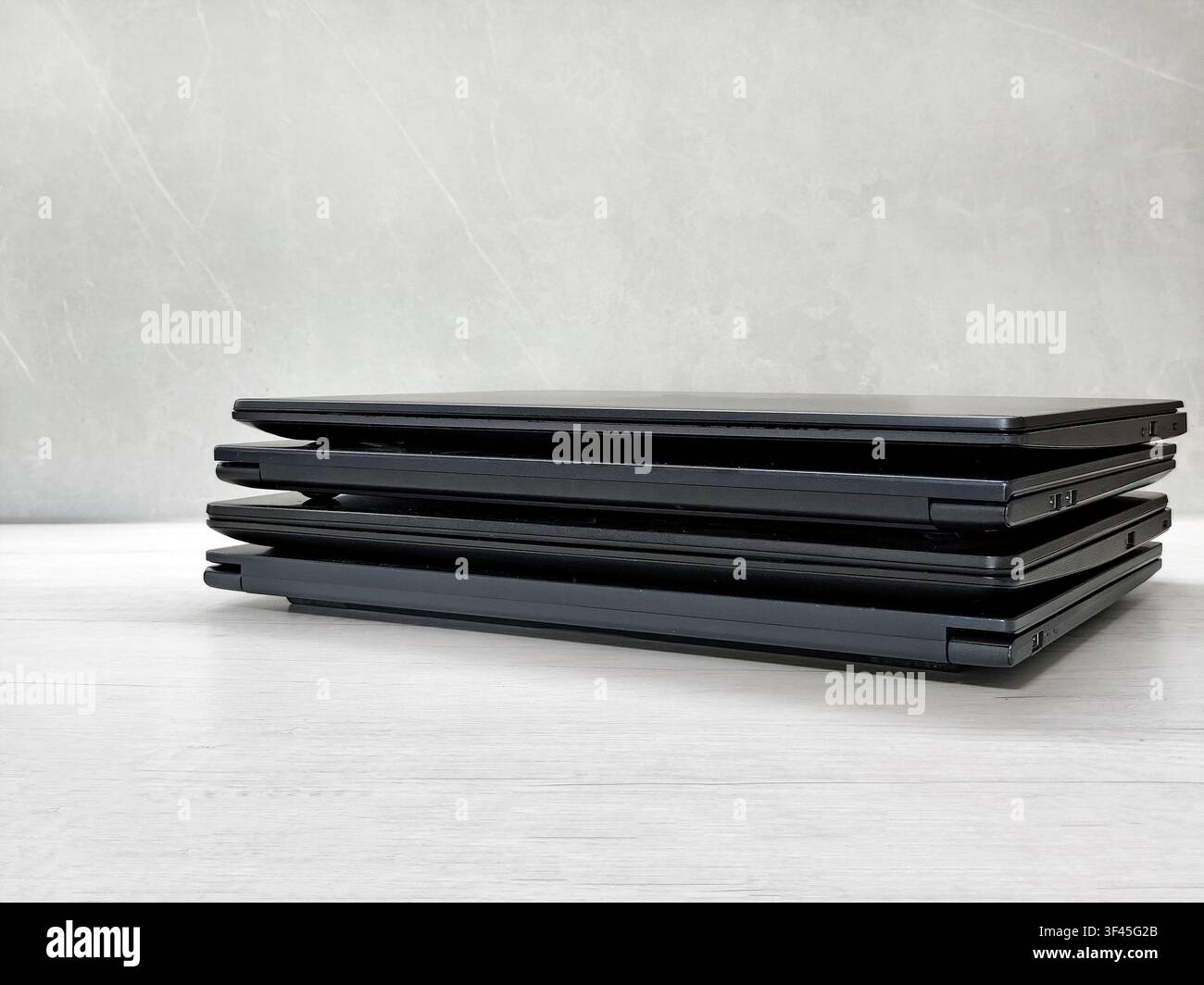 stack of laptops on a gray background, on the table, laptop computer, tablet, business, work, remote work, freelance. Stock Photo
