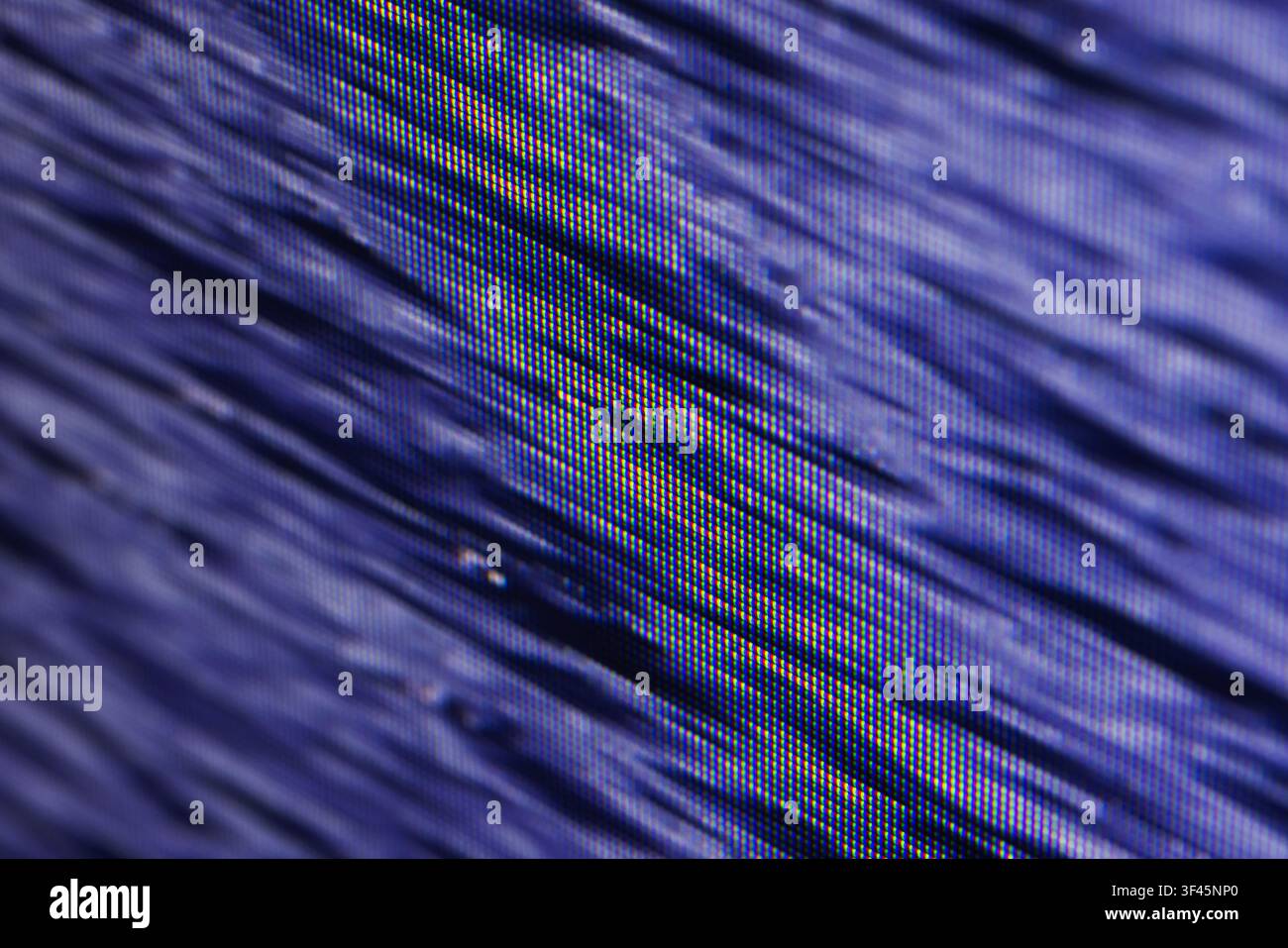 Macro view of a blue pixelated screen display revealing RGB subpixel structure and diagonal lines, creating an abstract textured pattern ideal for tec Stock Photo