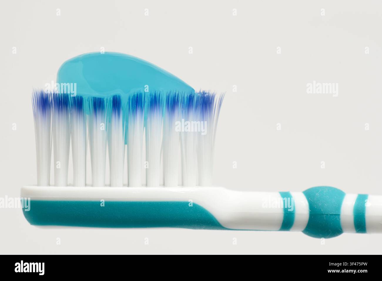 Toothbrush head with blue toothpaste on Stock Photo