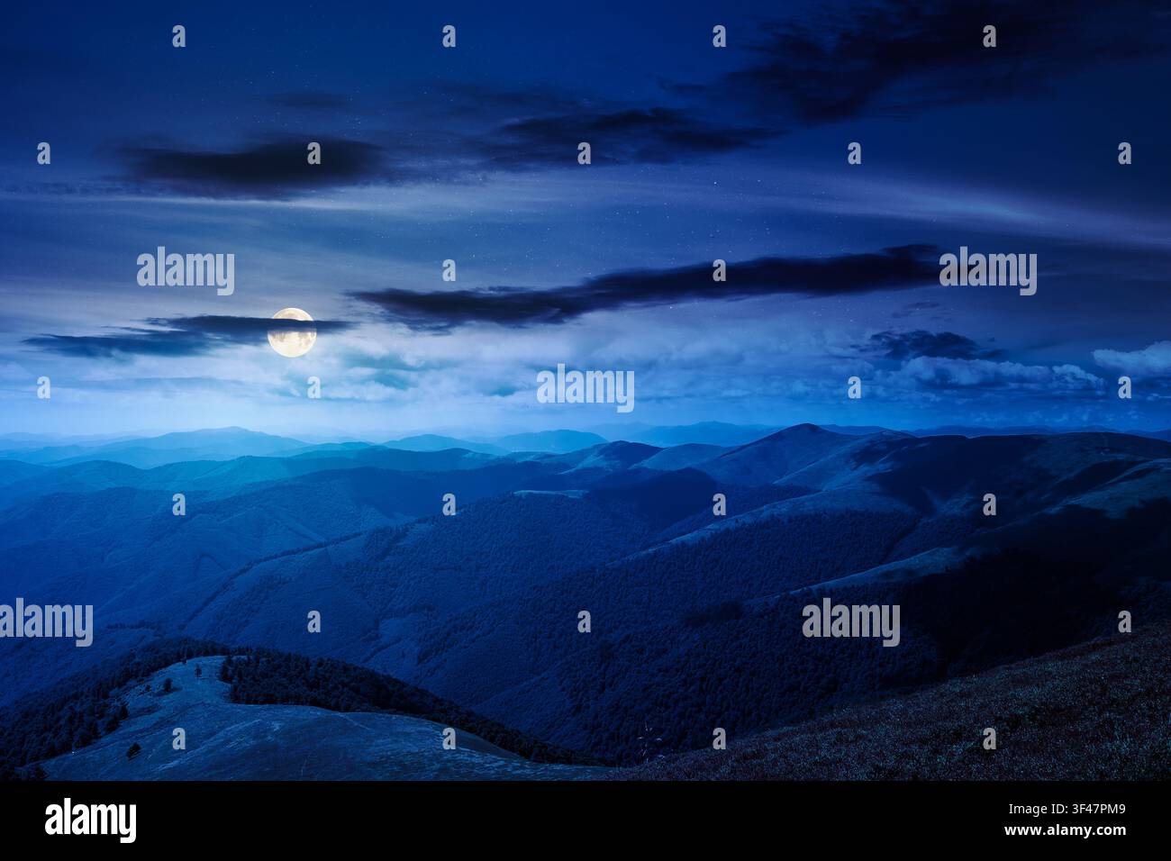mysterious mountain landscape in summer at night. travel ukraine background. full moon over rolling hill in dappled light. scenic view of borzhava rid Stock Photo