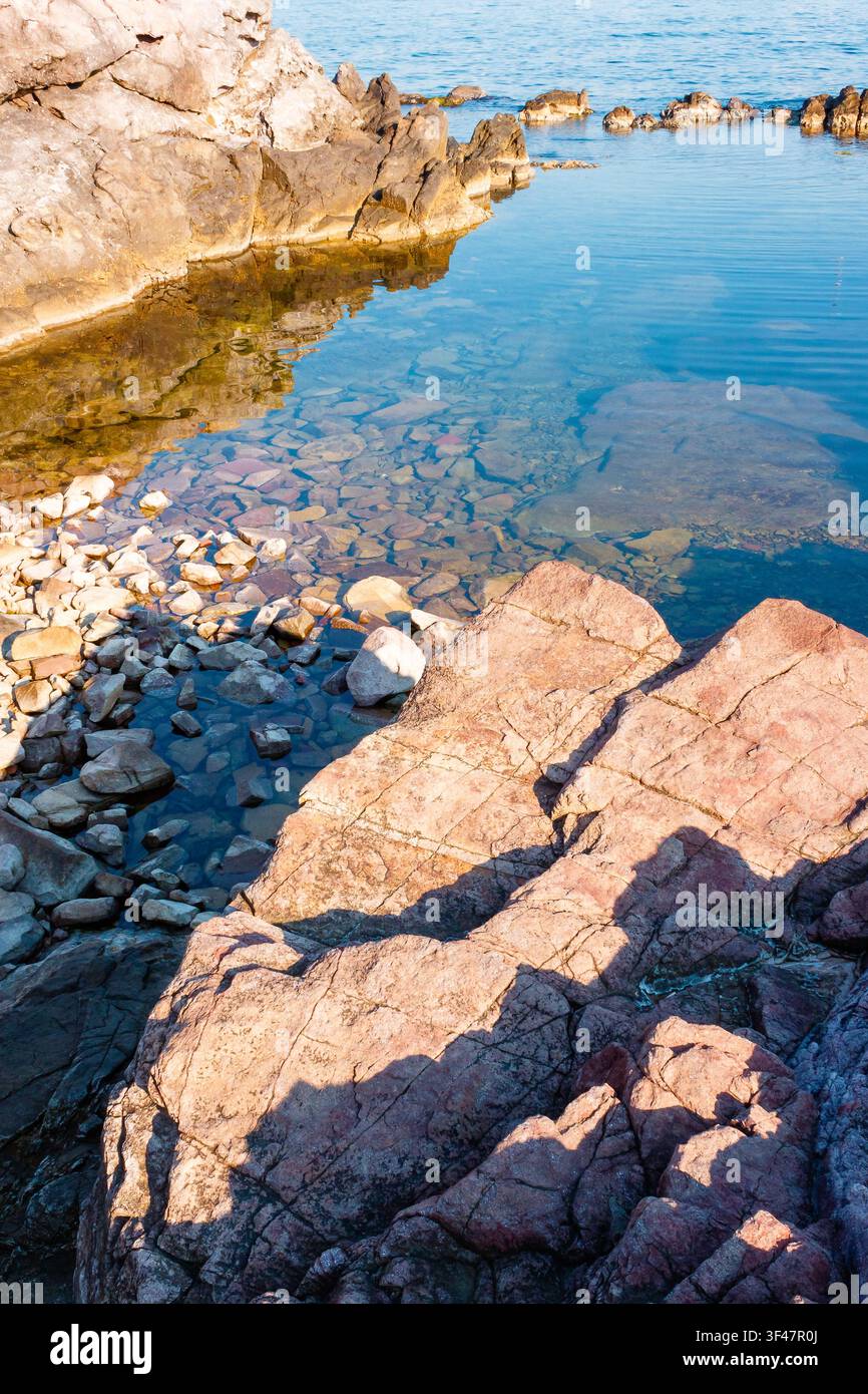 peaceful rock reflection in the sea water. calm summer vacation at the black sea. sunny weather Stock Photo