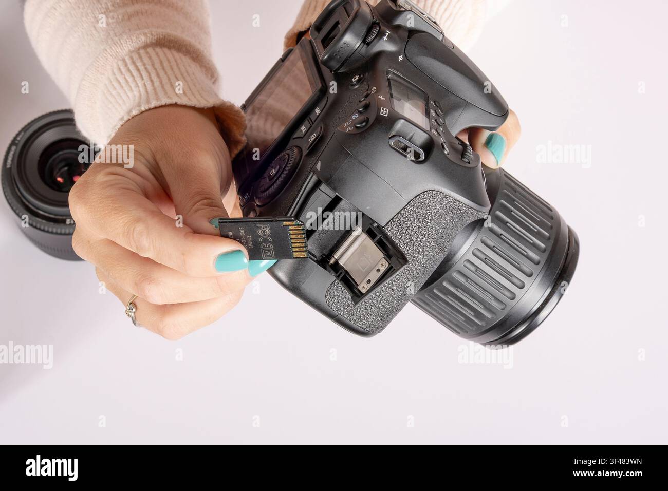 Inserting SD Memory Card into DSLR Camera Stock Photo